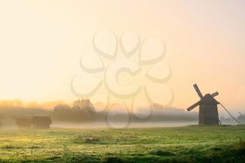 Royalty Free Photo of a Windmill in a Foggy Field