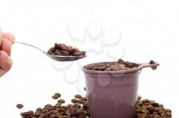 Royalty Free Photo of a Spoon Above a Cup Full of Coffee Beans
