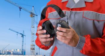 Royalty Free Photo of a Builder Holding Protective Headphones