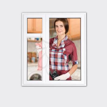 Royalty Free Photo of a Woman Standing by a Window Cleaning