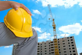 Royalty Free Photo of a Builder Holding a Yellow Helmet
