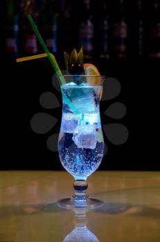 Light cocktail with orange and pineapple with soda at dark background
