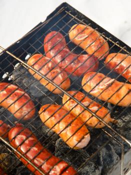 grilled sausages on grill, with smoke above it