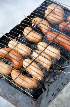 grilled sausages on grill, with smoke above it