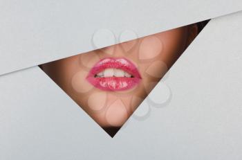 Beautiful female lips closeup behind silver metal background