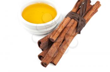 cinnamon sticks and honey on white background