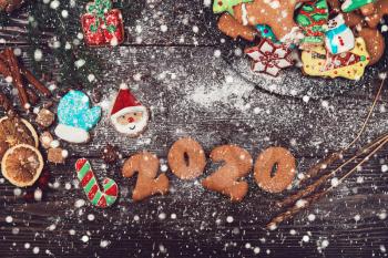 Gingerbreads cookies for 2020 new year on wooden background, xmas theme