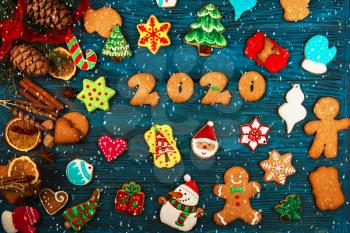 Different ginger cookies for 2020 New Year holiday on wooden background, xmas theme