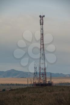 Telecommunications cell phone tower with antennas in a mountain location.