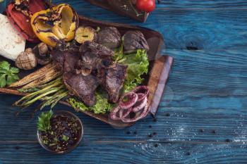 Grilled beef meat with vegetable on a blue wooden background