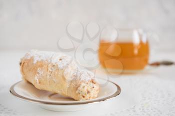 Tasty eclair on a white background with tea