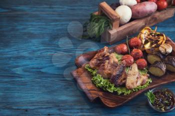Grilled chicken meat with vegetable on a blue wooden background