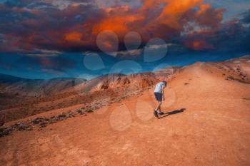 Teen boy in valley of Mars landscapes with beauty sky sunset