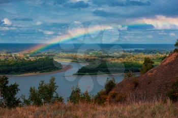 Rainbow with clouds over a river valley, autumn shot