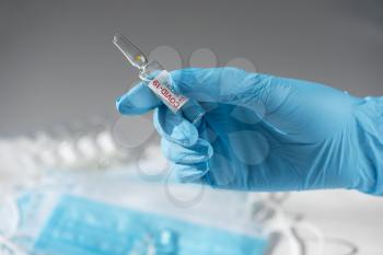 Coronavirus vaccine concept: New covid-19 vaccine with 90 percent efficiency in hand with blue protective gloves.