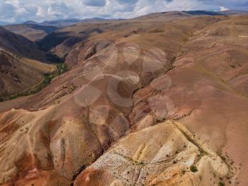 Aerial drone view of colorful eroded landform of Altai mountains with yellow, brown and red colors. Nature landscape in popular tourist location called Mars, near the border with Mongolia, Chagan-Uzun, Altai Republic, Russia