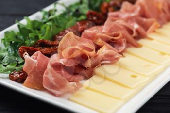Plate with prosciutto cheese and sun-dried tomatoes