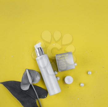 Colors of the year 2021: Ultimate Gray and Illuminating yellow concept. Makeup cosmetic products, flat lay, top view.