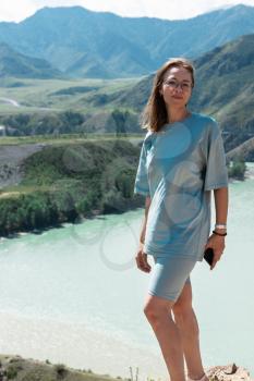 Domestic tourism, travel, lesure and freedom concept after pandemic- woman on the confluence of two rivers Katun and Chuya in Altai mountains, beauty summer day