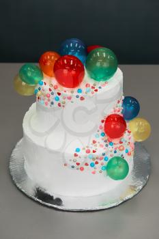 Wedding cake with balloons on grey background