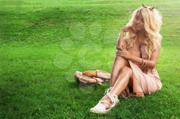 Rest in park, outdoor, people and leisure concept - beauty blonde alone young woman resting in the park