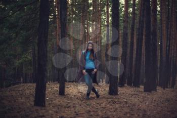 Art portrait of woman posing in the autumn dark forest