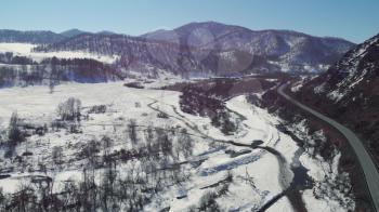 Aerial view of a road in winter landscape of Altai mountains