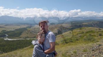 Happy man with his son in Altai mountains. Vacation, travel and adventure concept