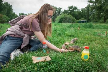 Woman feeding gopher in the summer park
