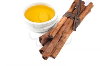 cinnamon sticks and honey on white background
