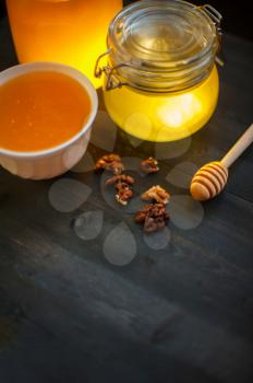 Honey with walnut on wooden background
