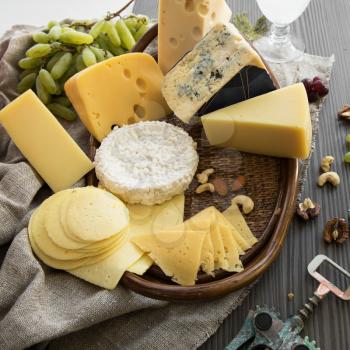 Various types of cheese set with grapes and nuts