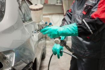 spray gun with paint for painting a car