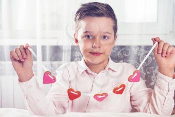 Young boy with gingerbread heart cookies. To Illustrate the Happy Valentines Day or Mother day.