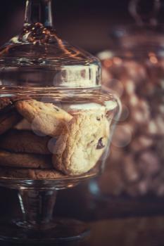 Oatmeal cookie in glass jar, closeup photo