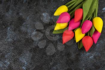 Handmade tulips on darken concrete background for Mother's Day, spring time or Easter theme.
