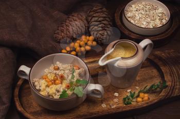 oatmeal with sea buckthorn butter and greens with pine nuts and sauce