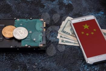 Bitcoin coin on HDD with smartphone with China flag