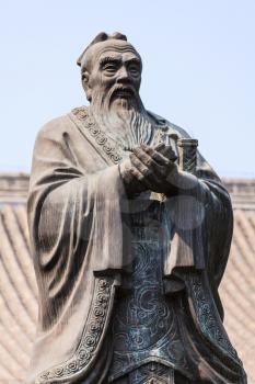 Bronze statue of Confucius, chinese teacher and philosopher against blue sky
