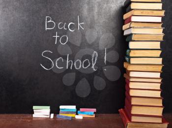 Royalty Free Photo of Back to School Written on Chalkboard With Books
