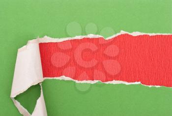 Green torn paper on red paper