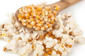 Corn seeds and popcorn with wooden spoon