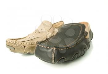 Modern beige and black mens moccasins over white background (wide angle shot)