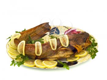 Tasty dinner - bloated fresh-water catfish (sheatfish) with lemon and parsley on the plate