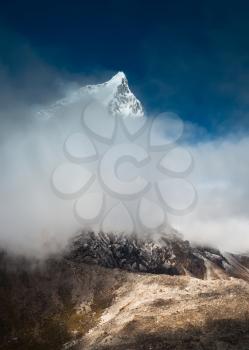 Cholatse (6335m) peak hidden in clouds in Himalayas