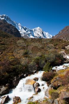 Himalaya landscape: snowed peaks and stream. Pictured in Nepal
