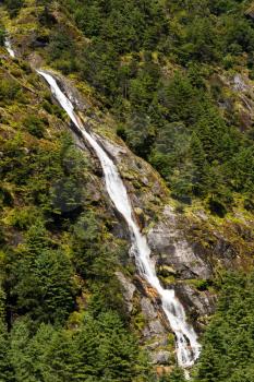 Himalaya Landscape: waterfall and forest trees. Travel to Nepal