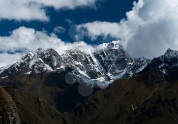 Snowbound mountain peaks and clouds in Himalayas. Pictured in Nepal