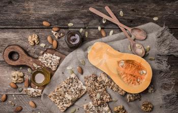 Pumpkin, nuts,  honey and seeds on wooden table. Rustic style