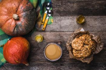 Pumpkins, soup, honey and cookies with nuts on wood. Autumn Season food photo